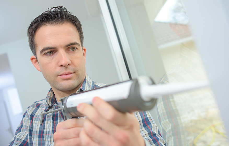 a man fixes a window seal